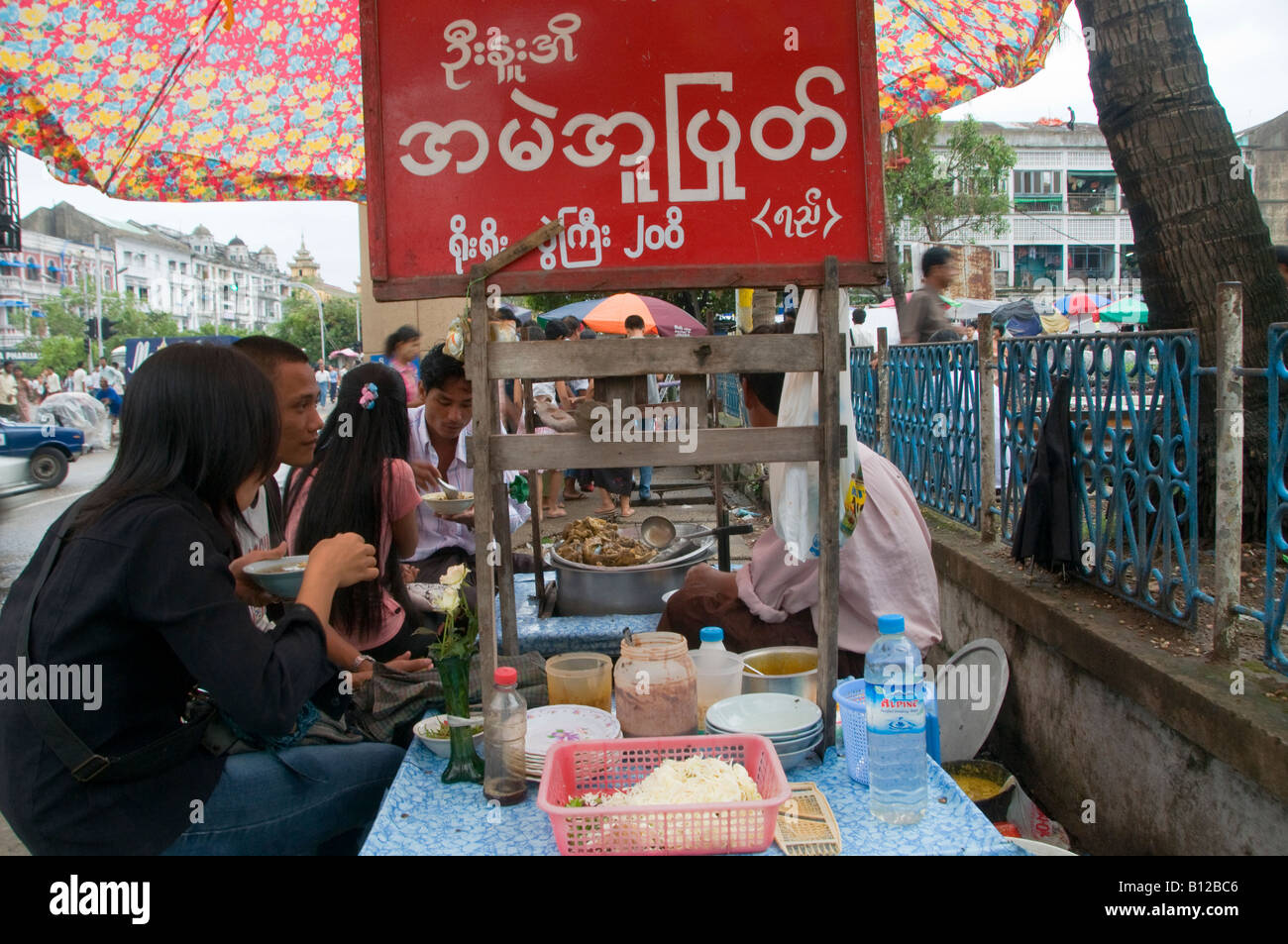 People eating meat soup in a portable food booth in Yangon, Myanmar