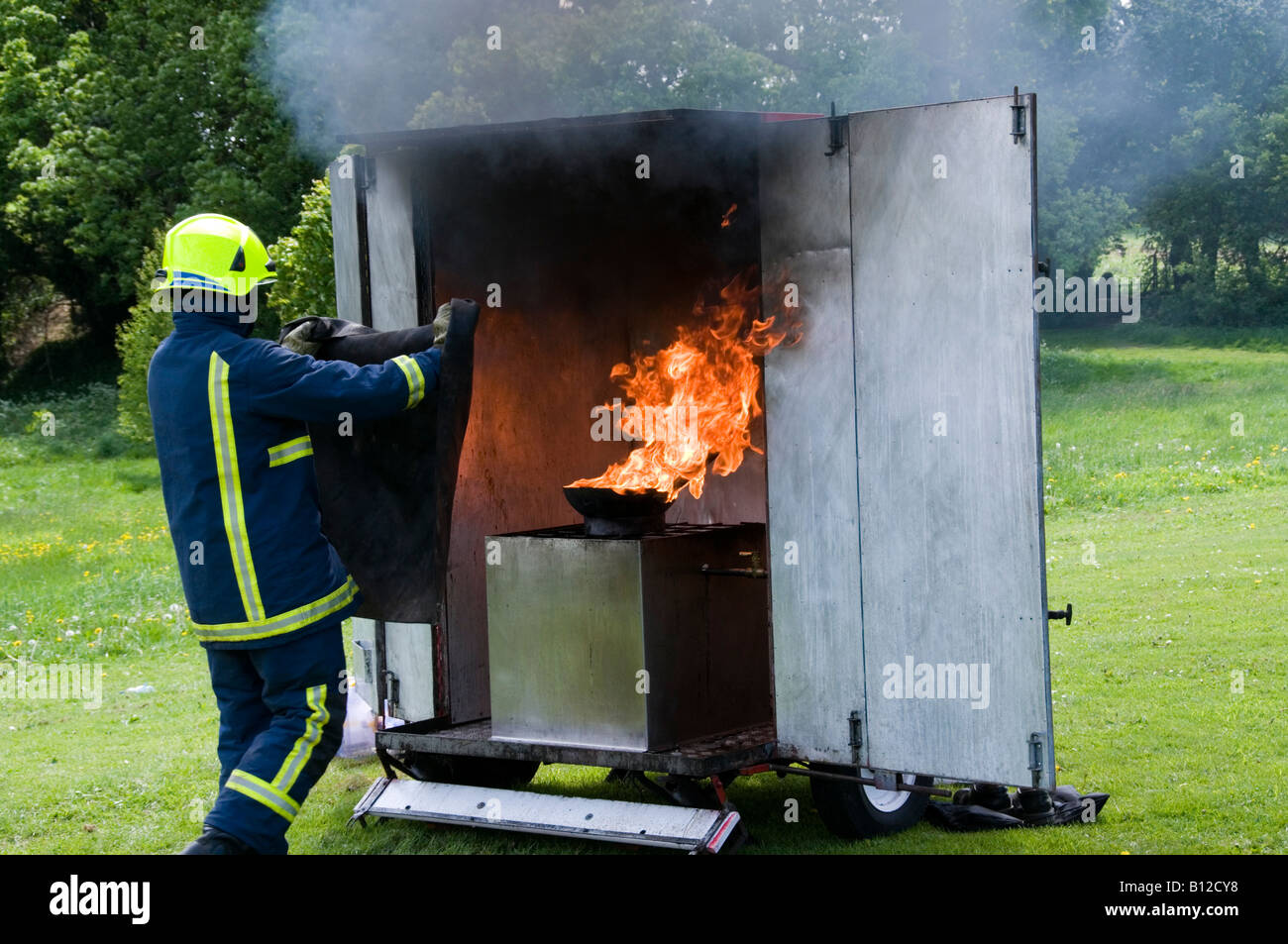 Fireman in England demonstrating how to put out a chip pan fire using a