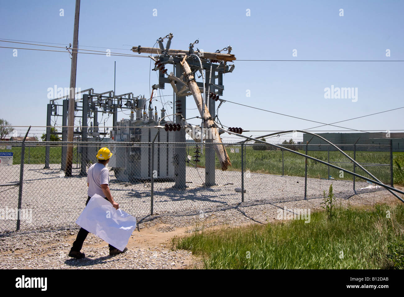 A utility worker inspects a damaged electrical substation near East