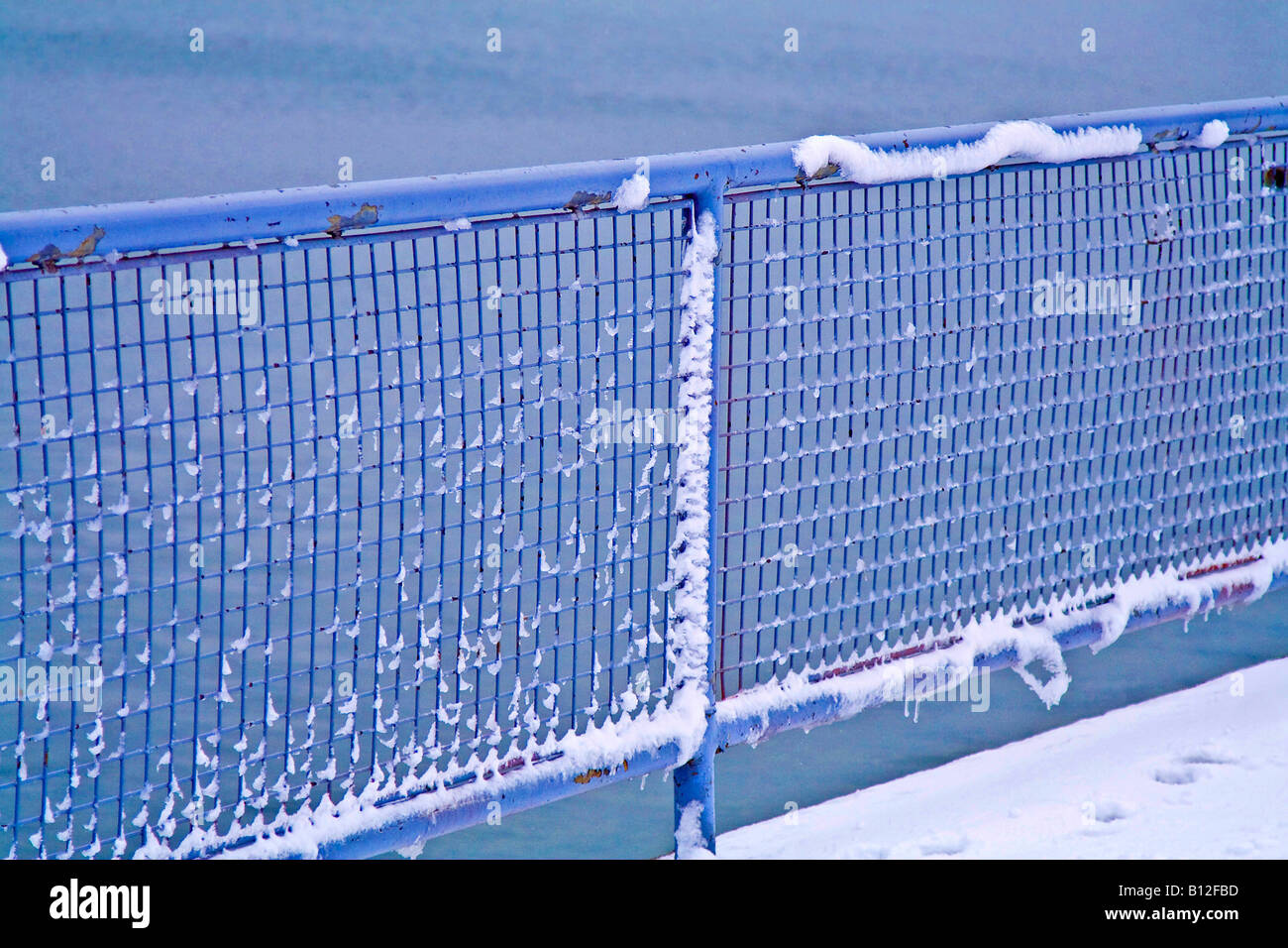 Metal fence covered with snow Stock Photo - Alamy