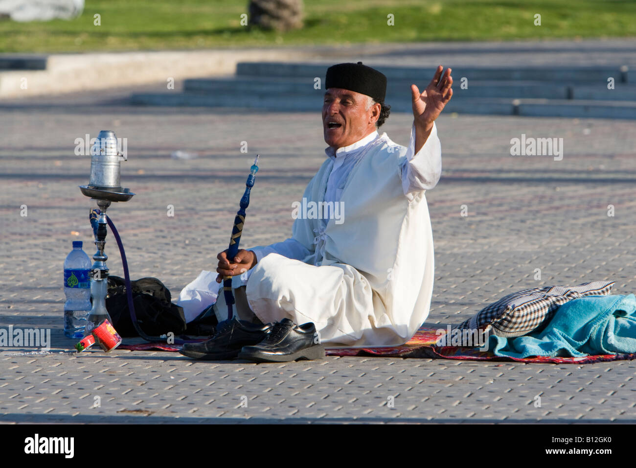Tripoli, Libya, North Africa. Man with Water Pipe, Sheesha, in Public Park near the Green Square, wearing a chechia, a traditional Tunisian hat. Stock Photo