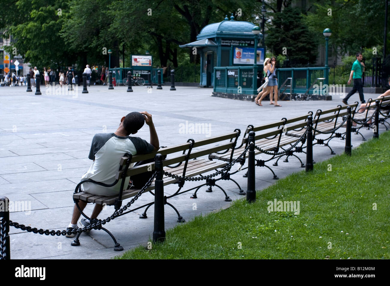 A man sitting on a bench outside the Chambers Street station in Manhattan, NY. Stock Photo