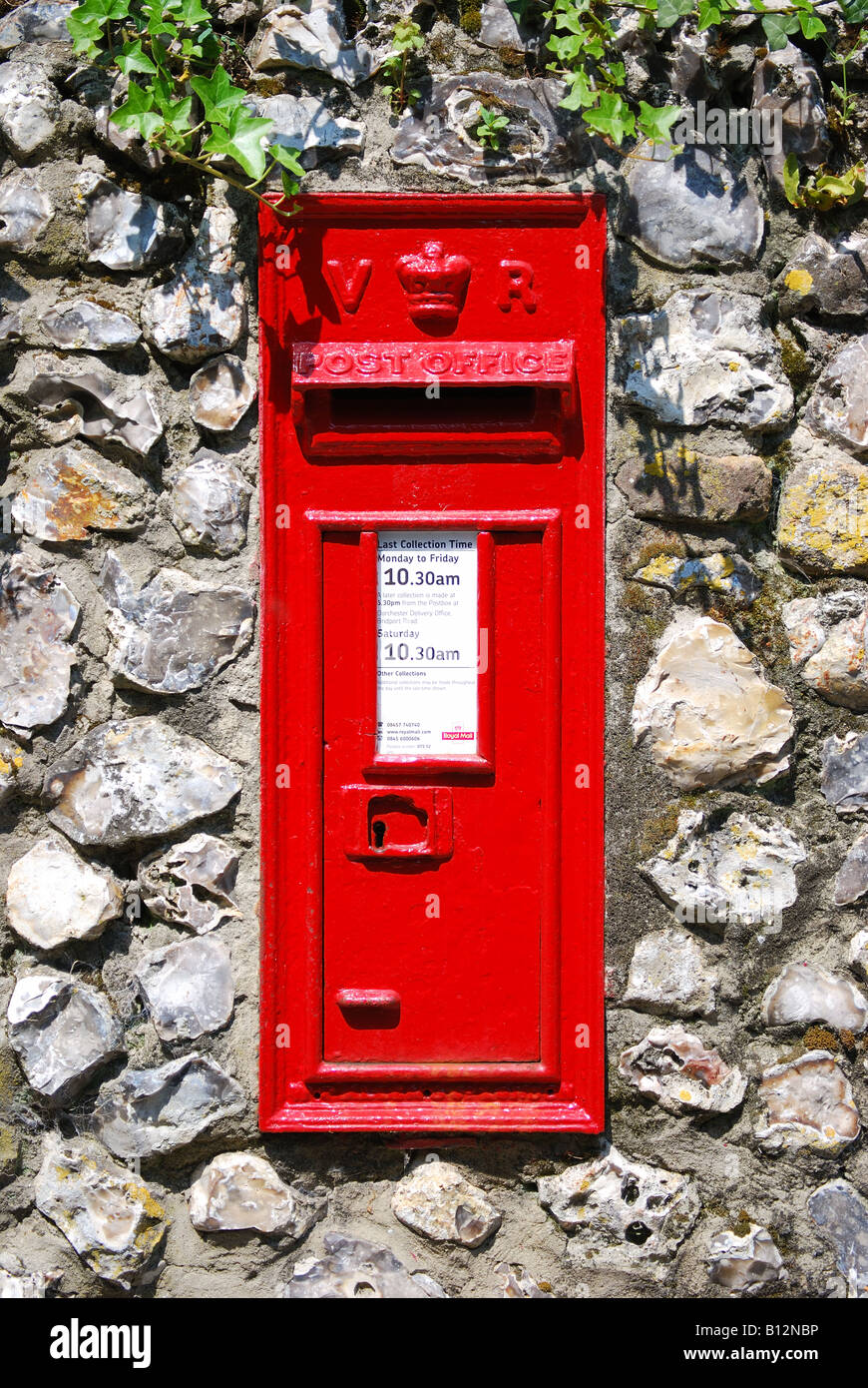 Red Victorian post box on stone wall, Wimborne Minster, Dorset, England, United Kingdom Stock Photo