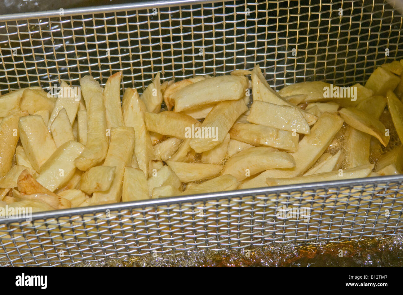 Chips draining over Deep Fat fryer Stock Photo
