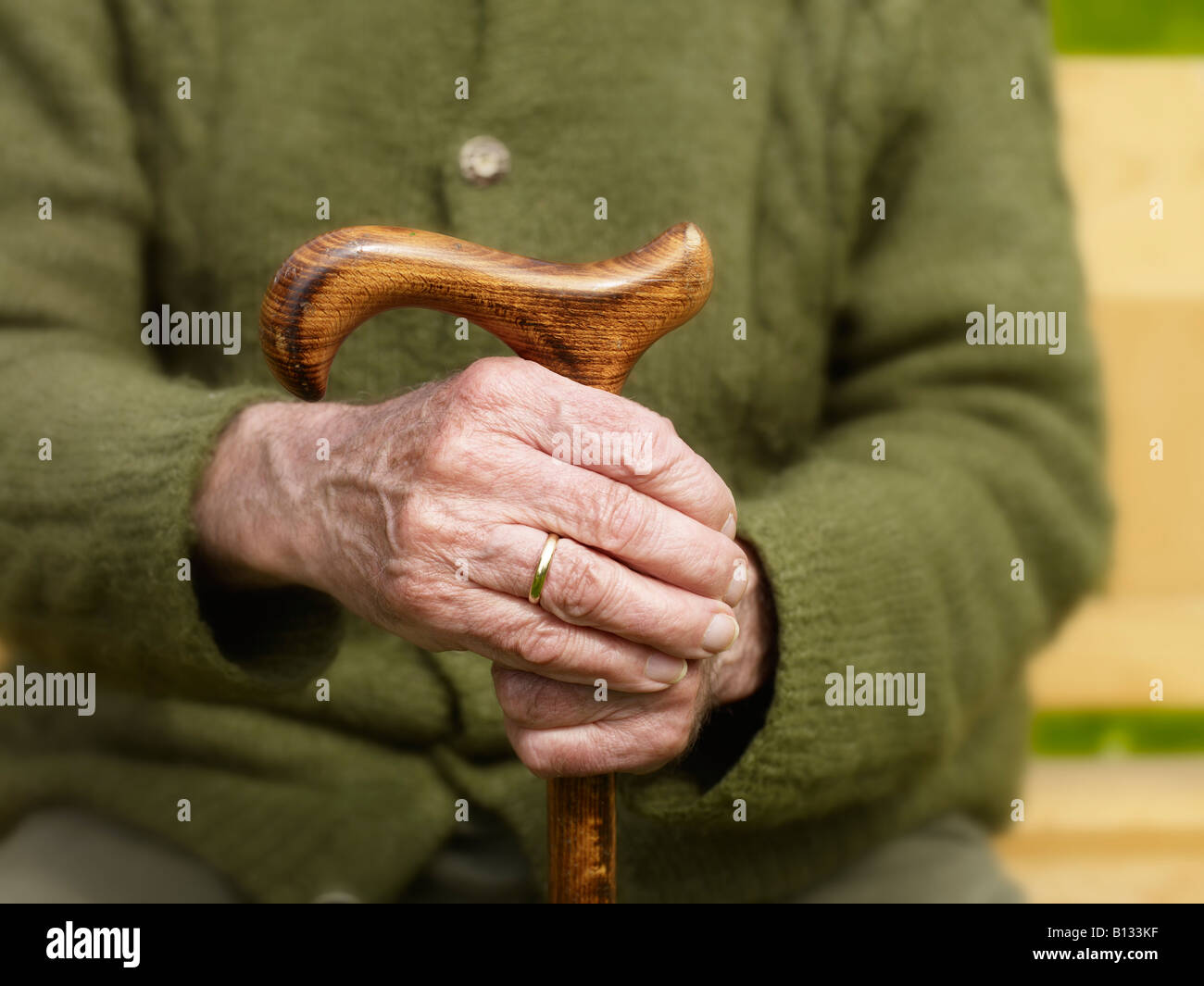 sitting old man with his hands on a cane Stock Photo