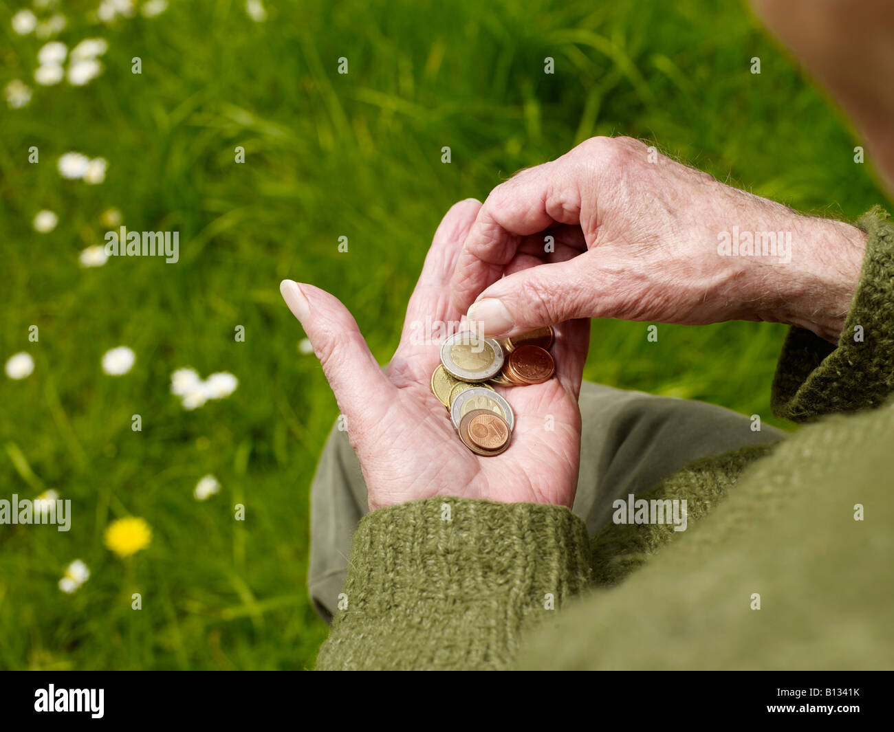 old hands of a senior counting less money, coins Stock Photo
