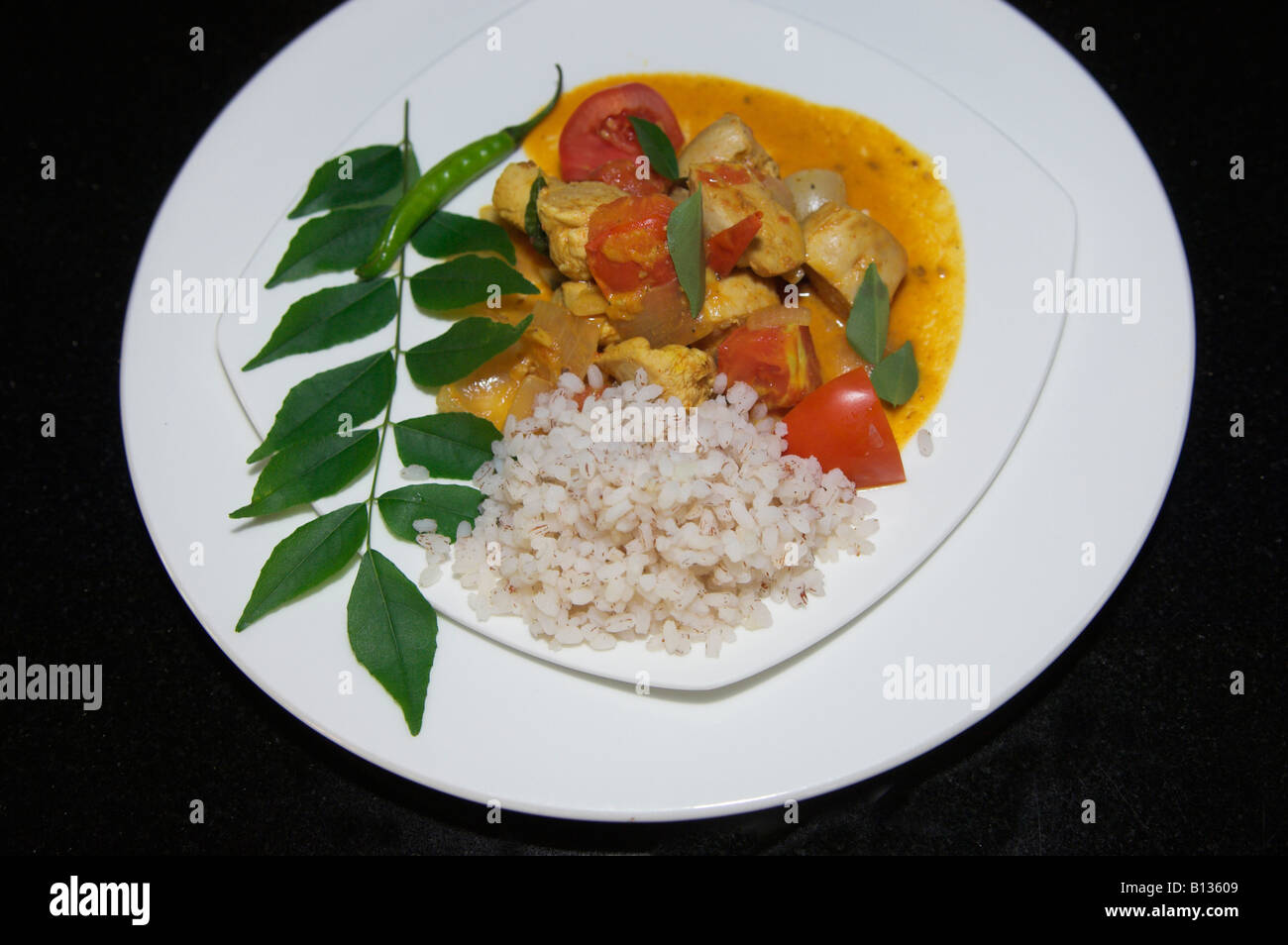 Plate of chicken curry Indian food with rice and garnish ready to serve Stock Photo