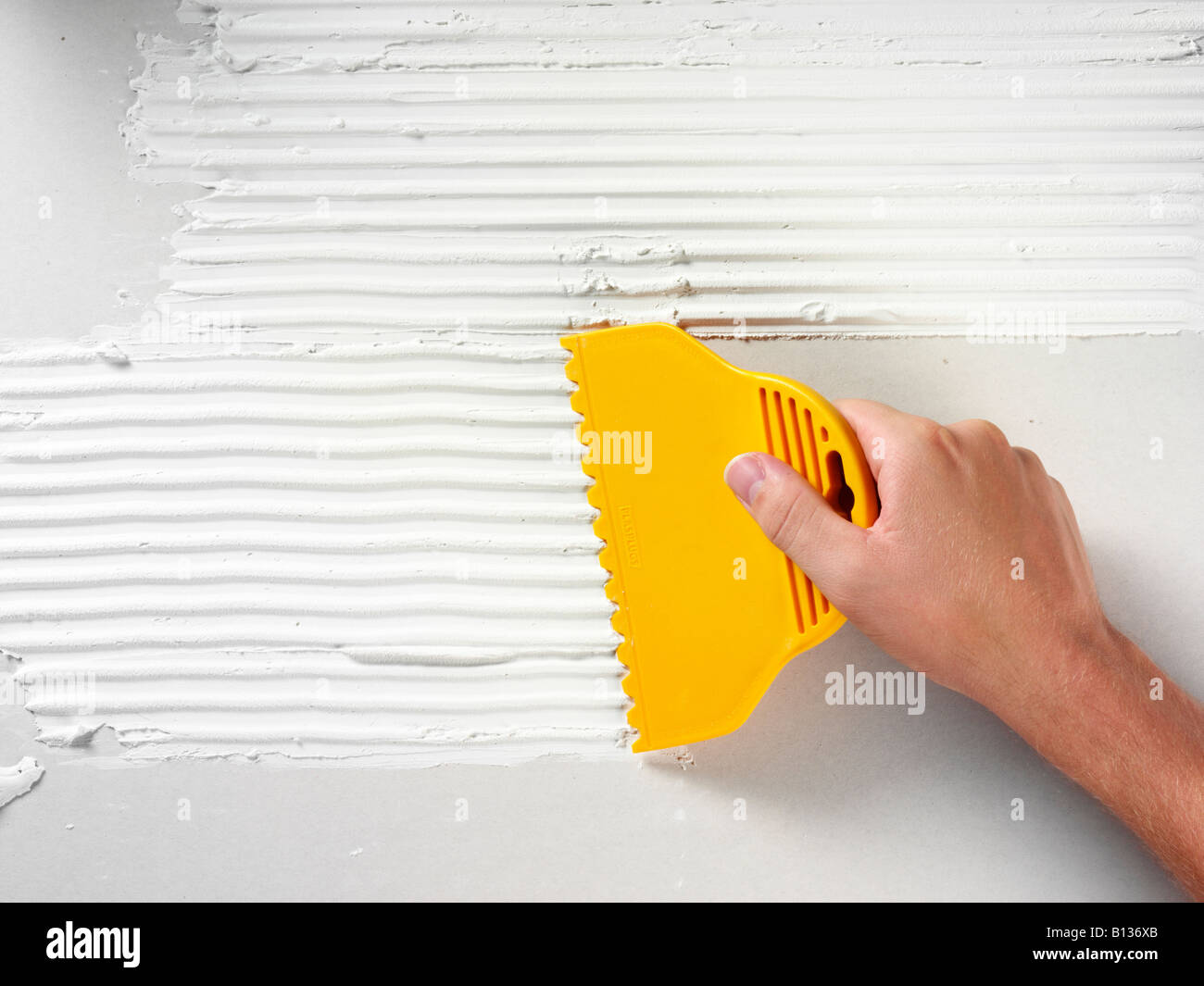 MAN APPLYING TILE ADHESIVE TO WALL Stock Photo Alamy