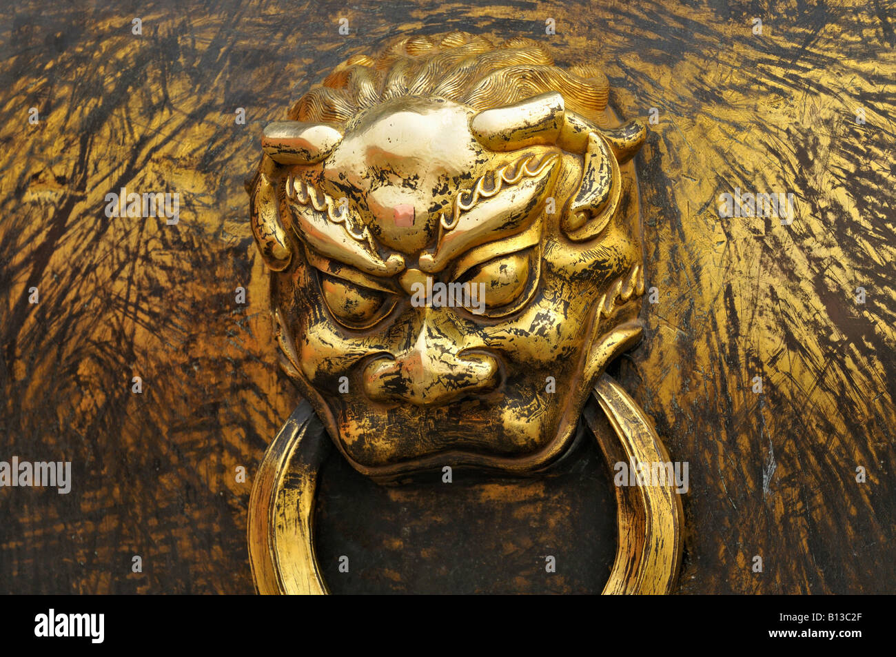 Handle of bronze gilt urn or water carrier in the shape of a devil or gargoyle Forbidden City Beijing China Stock Photo