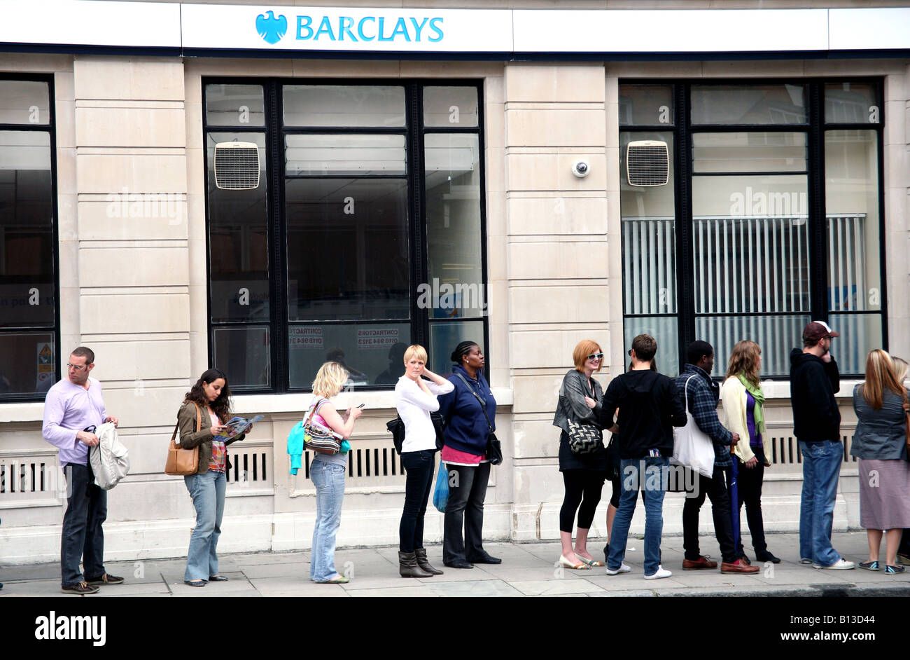 Customers queuing for cash machine in London street Stock Photo
