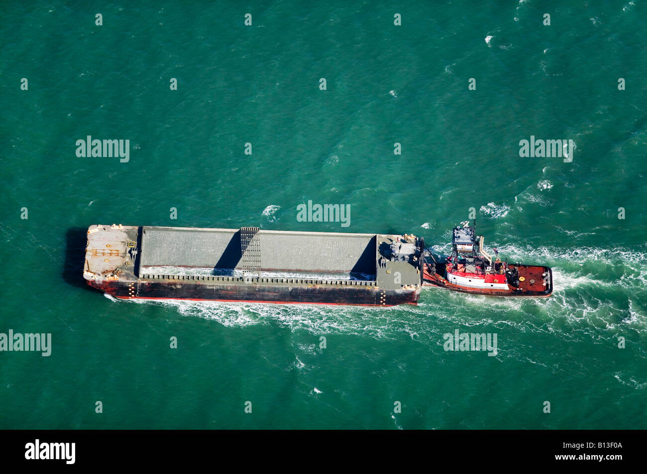aerial above tug boat pushing empty barge San Francisco bay Stock Photo