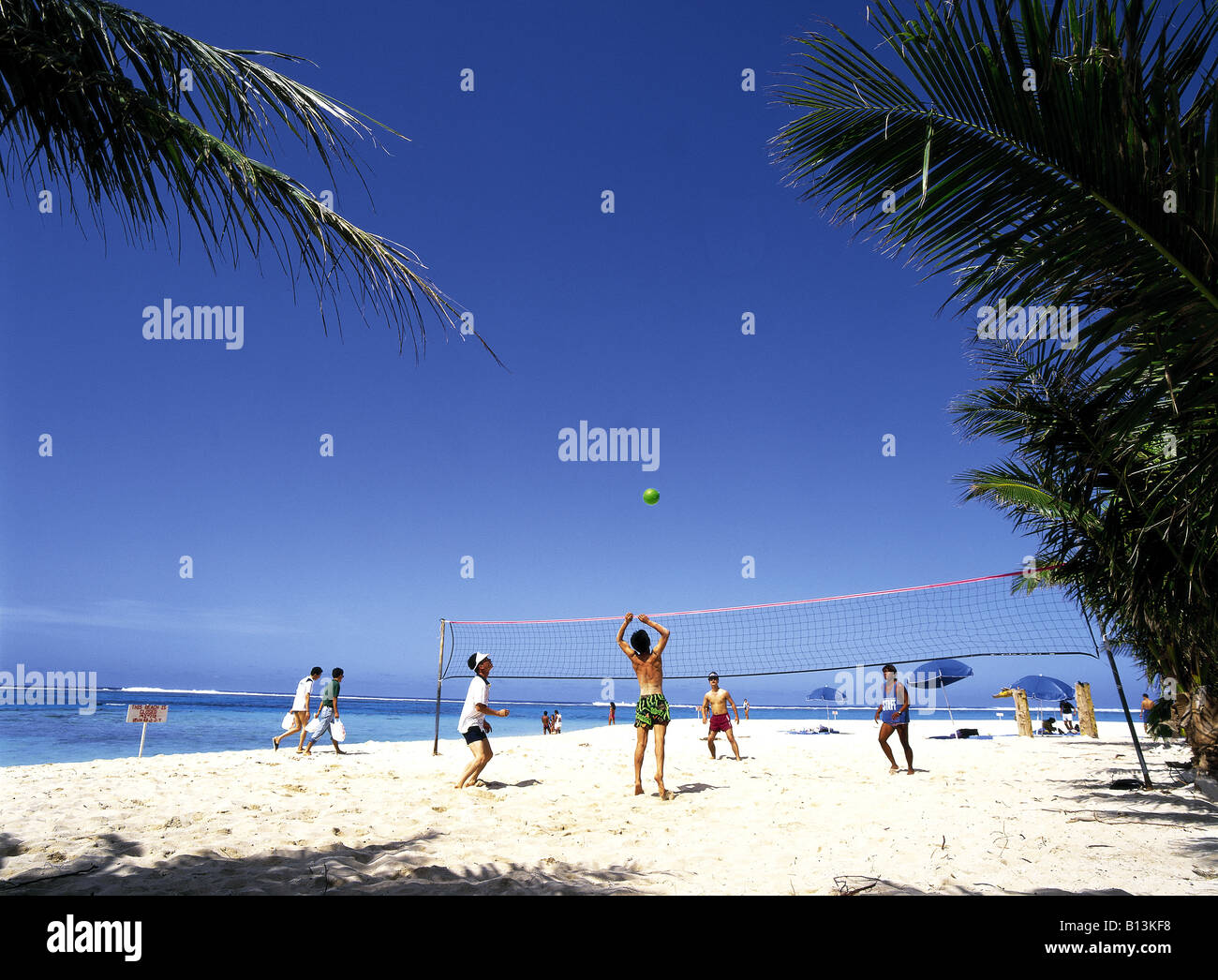 Men playing beach volleyball on the Pacific island of Saipan Mariana Stock Photo