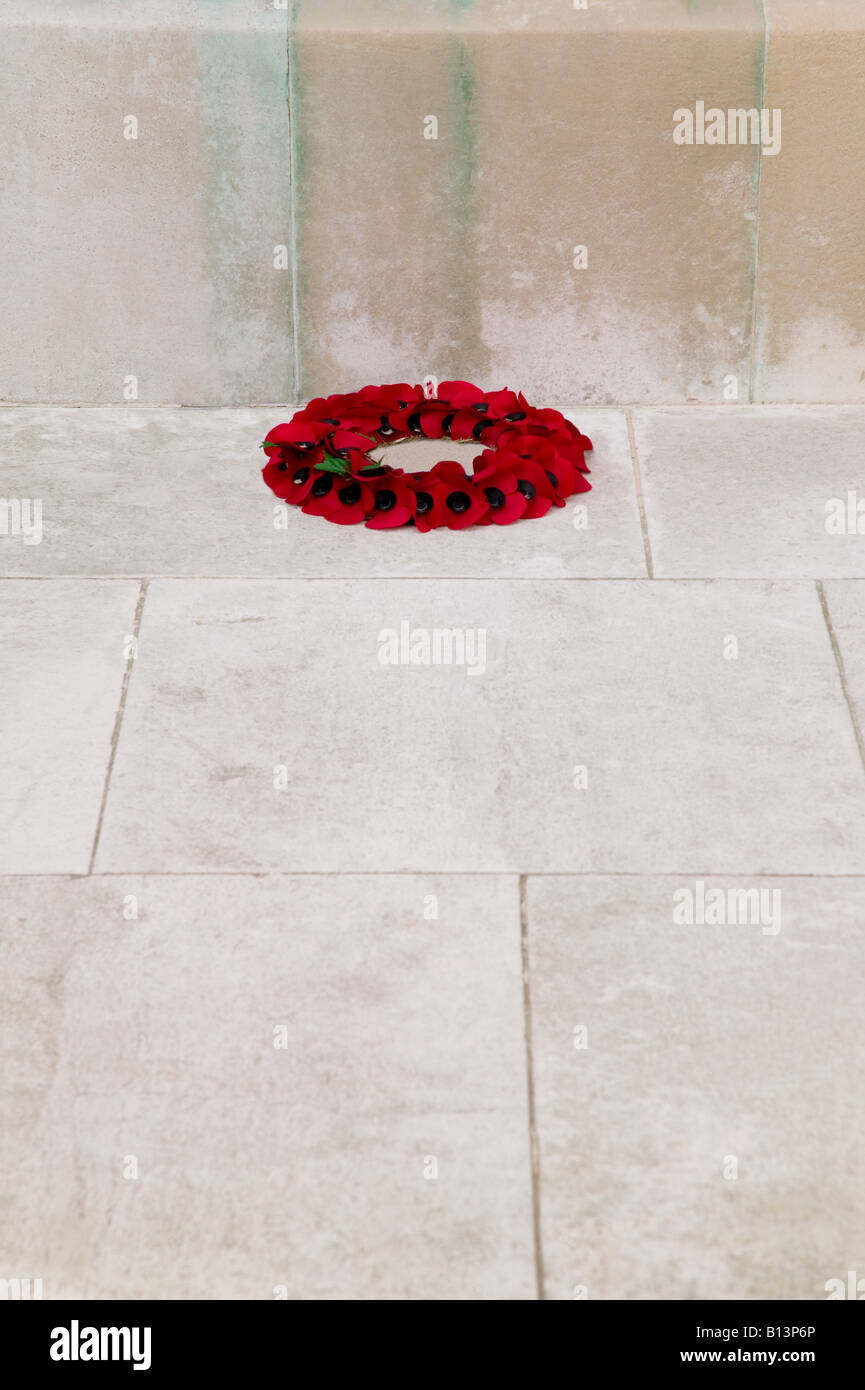 A single poppy wreath at the base of a war memorial on rememberance Sunday Stock Photo