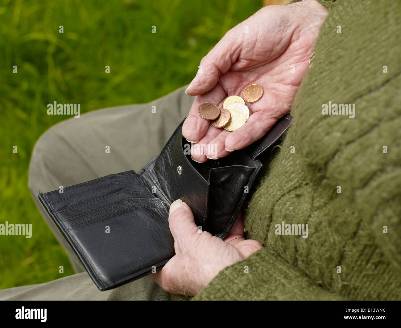 old hands of a senior counting less money in a purse Stock Photo