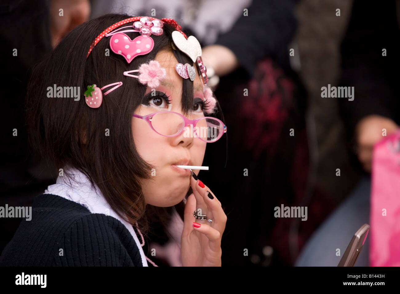 A Japanese fashion victim expressed her individualistic personality whilst enjoying a lollypop in Harajuku, Japan. Stock Photo