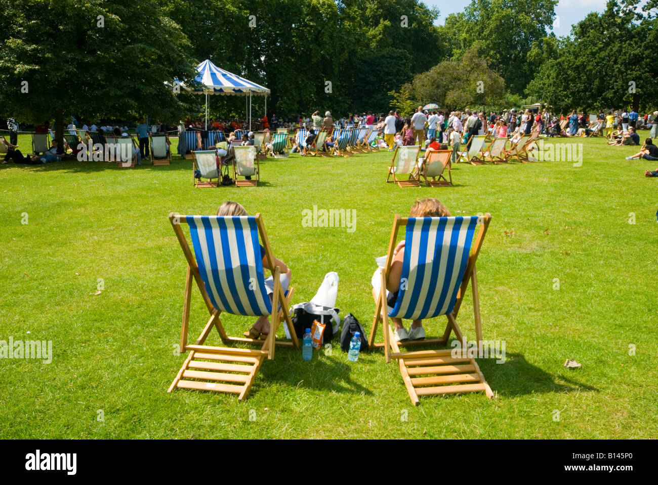 People in deckchairs watching band play in green park hires stock