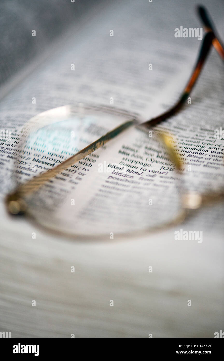 A pair of glasses on a dictionary highlighting the word Blind Stock Photo