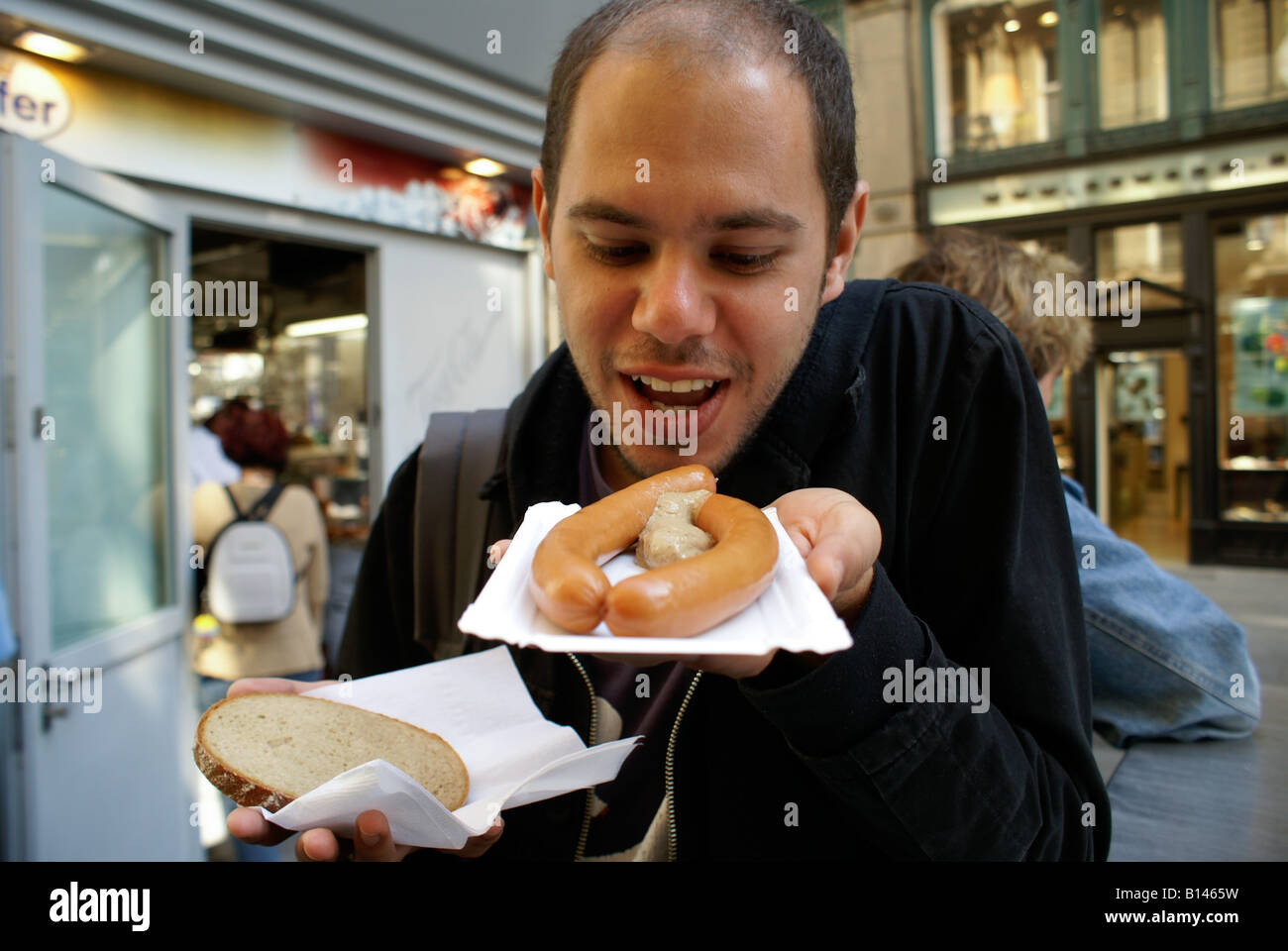 man eating a wienerwurst (sausage from Vienna) Stock Photo