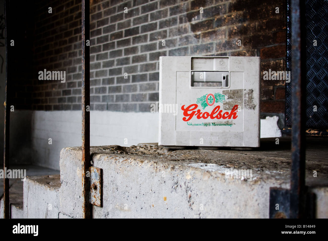 A Grolsch lager beer crate abandoned on an urban inner-city step. Stock Photo