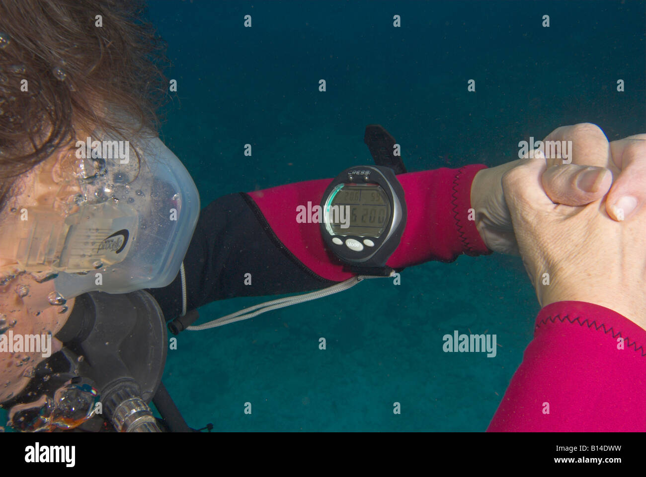 Closeup woman scuba diver checking dive computer on wrist for safety