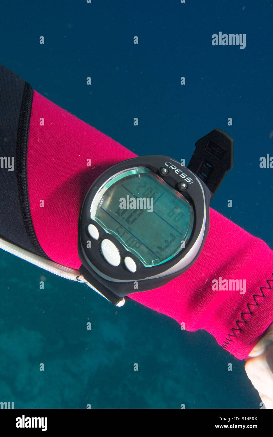 Closeup wrist mounted dive computer underwater showing depth and 3