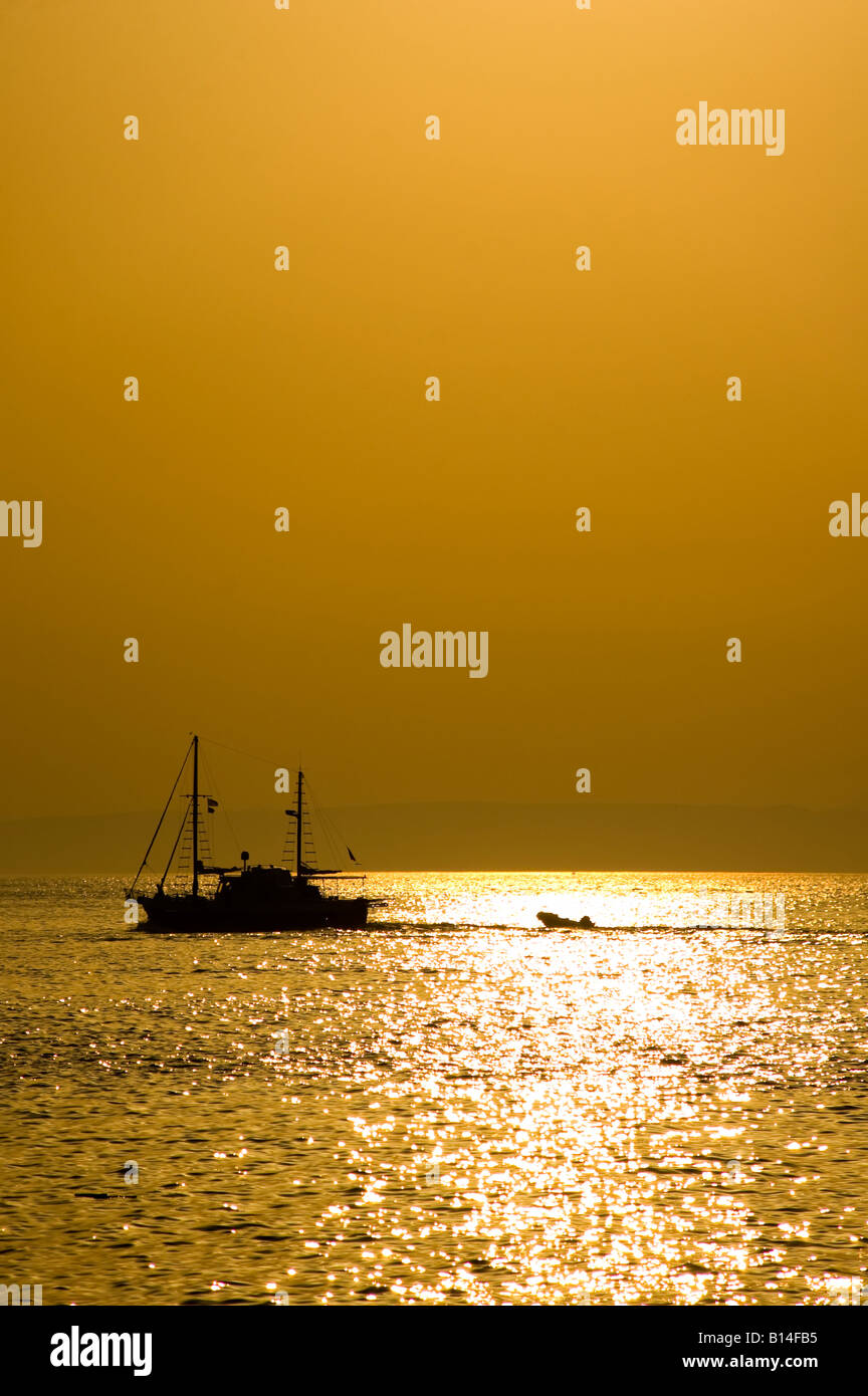 Fishing Trawler returning at sunset Stock Photo - Alamy