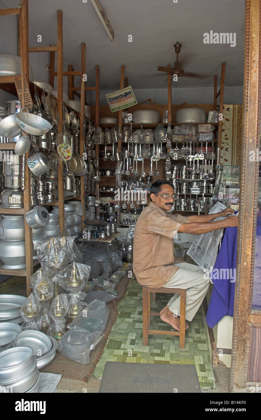 Indian small business owner in small shop in India selling pots and