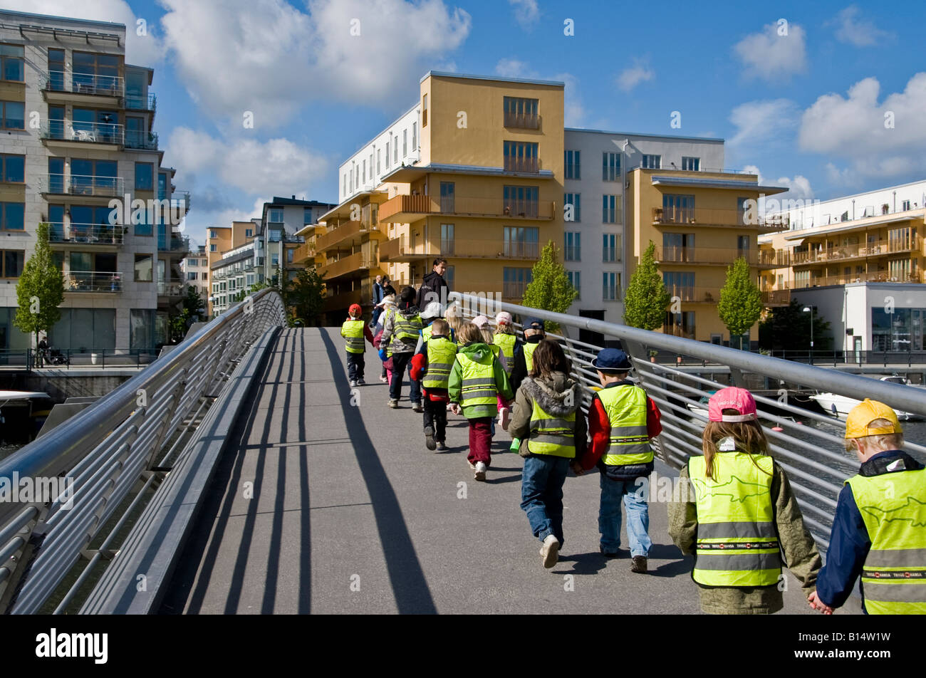 Teacher leading a class of very young school children on a walk through Stockholms most modern neighbourhood of Hammarby Stock Photo