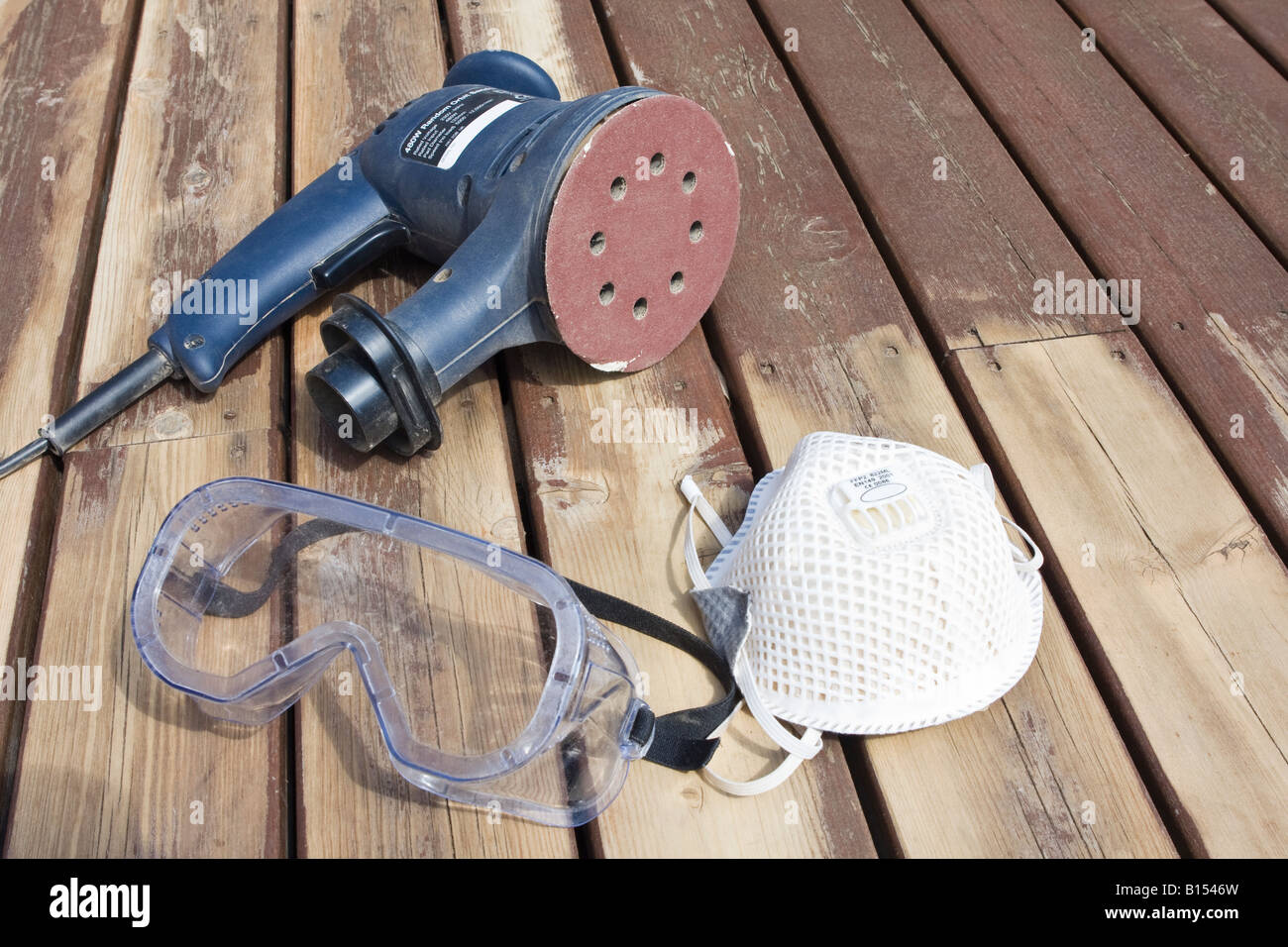 Orbital sander on its side showing sanding disk on partially sanded