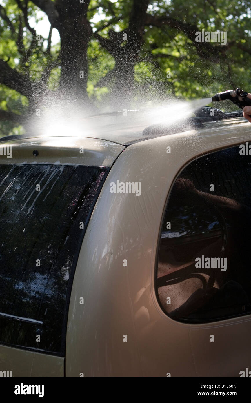 Spraying water rinses soap off of washed car Stock Photo Alamy