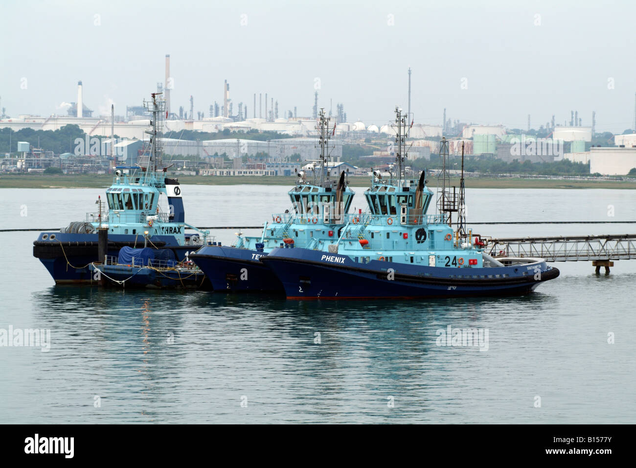 Ocean going berthing tugs on Southampton Water England UK Backdrop of the Fawley Marine Terminal Stock Photo