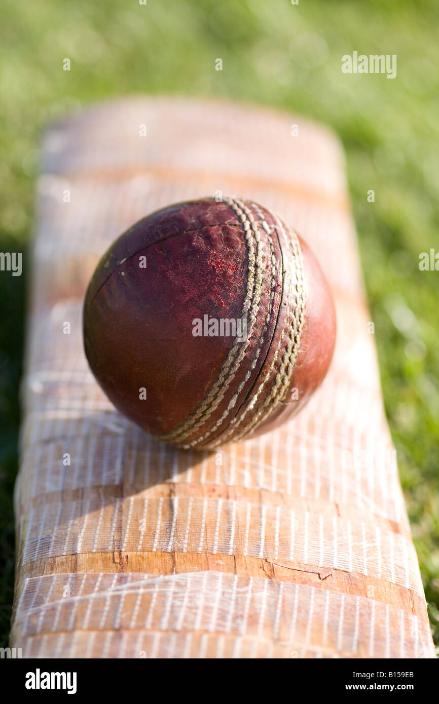 An old ball lies on and old cricket bat Stock Photo