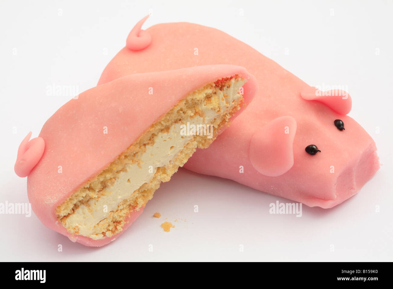 Pink pig-shaped cream sponge cake and slice. Stock Photo