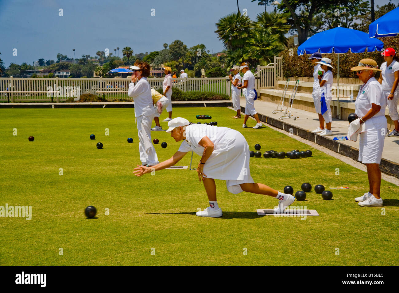 Women players roll balls at a lawn bowling competition on a bowling green in Laguna Beach CA Stock Photo