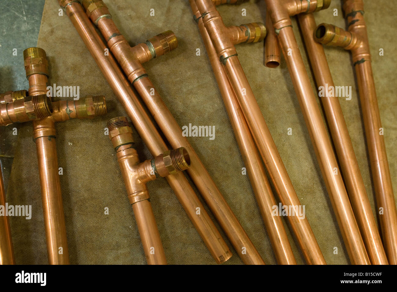 Copper water pipes lie on the floor, waiting to be installed Stock