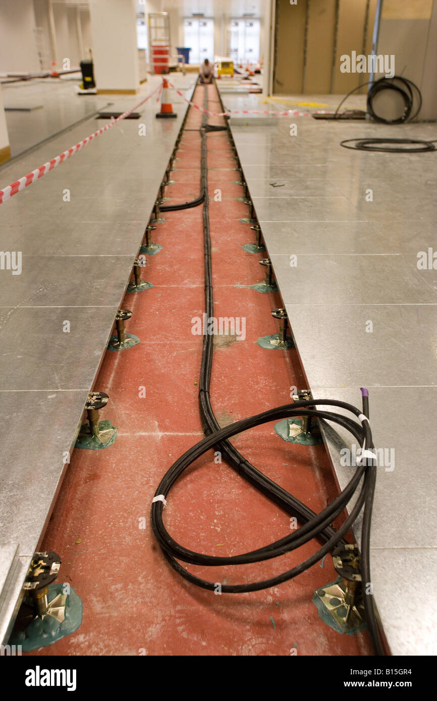 Mains cabling is routed under a raised floor in a newly constructed office building. Stock Photo