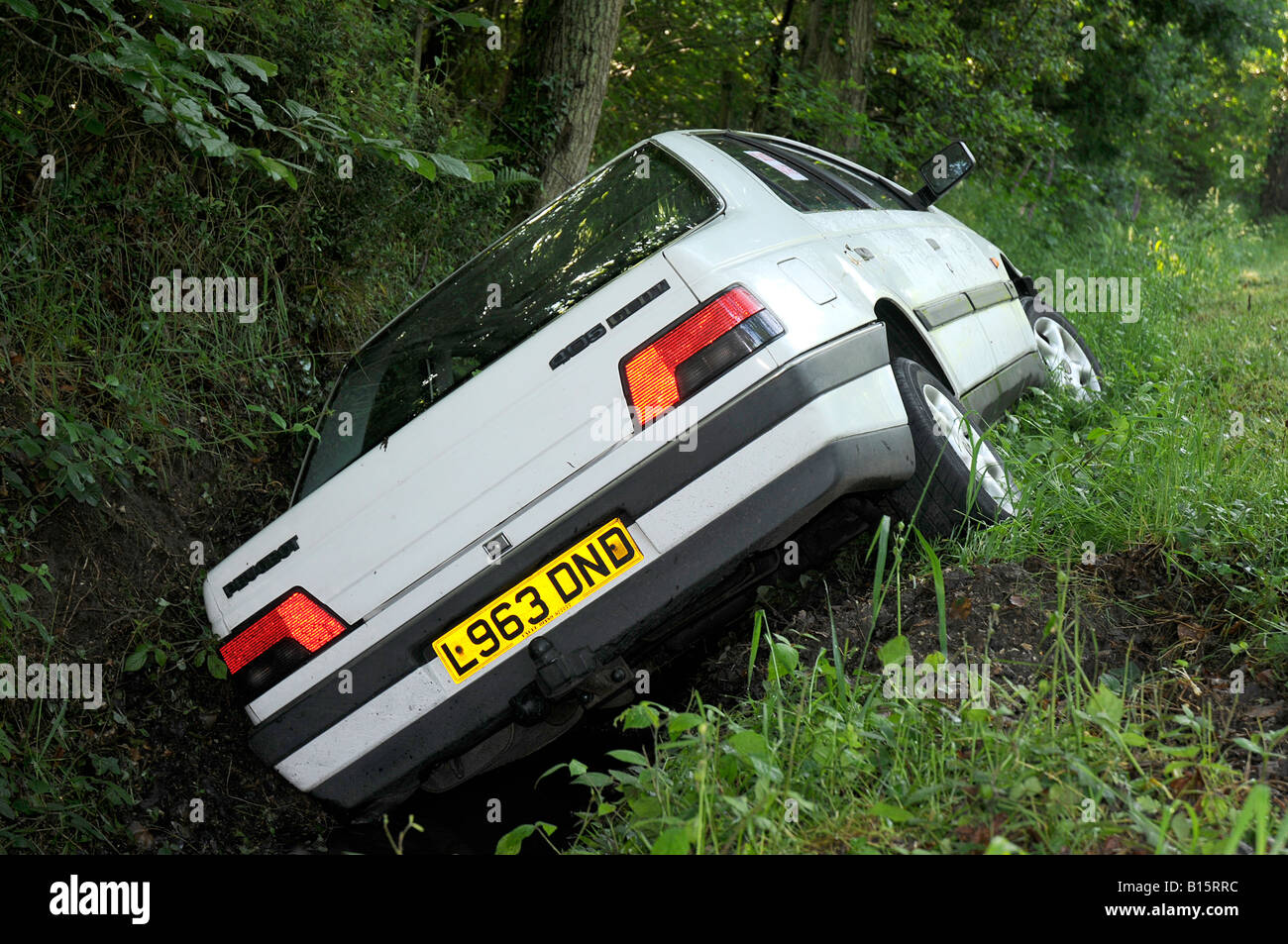 Peugeot 405 lying in a ditch with Police Aware sticker on side window Stock Photo