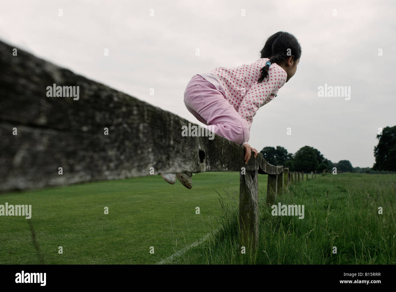 Child jumps over fence Stock Photo