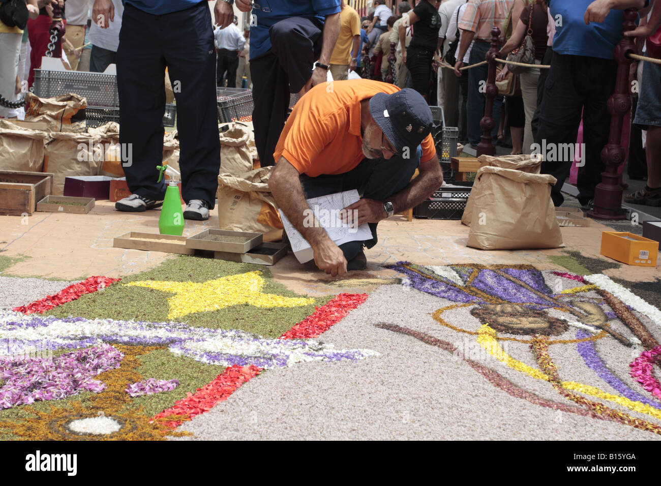 An alfombrista concentrating hard making the flower carpets from petals seeds and volcanic sand to celebrate Corpus Christi in La Oratava, Tenerife Stock Photo