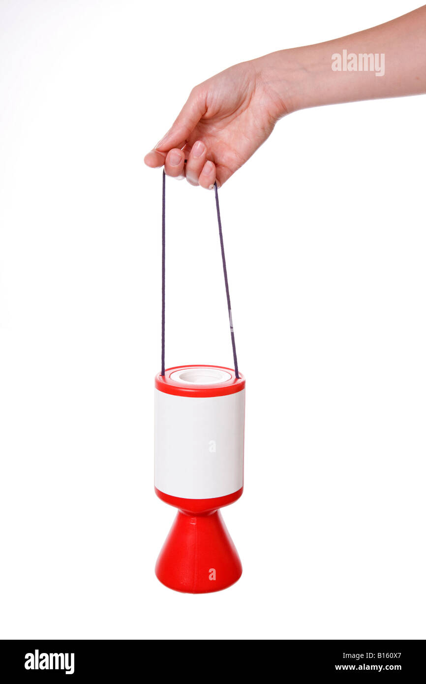 Red charity box collecting tin with hand holding it on string against white background Stock Photo