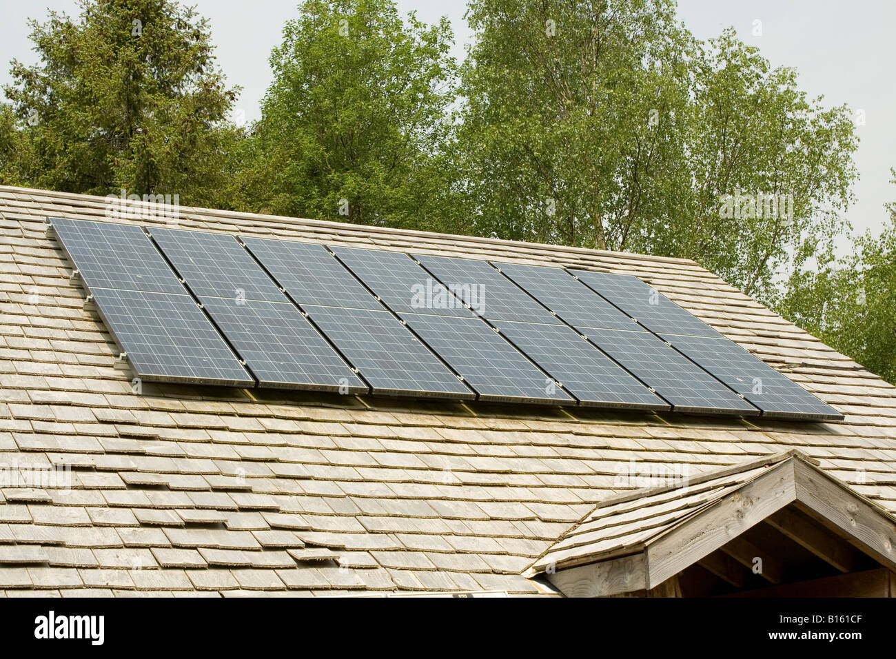 Seven solar PV panels on wood shingle roof Centre for Alternative Technology Machynlleth Powys Wales UK Stock Photo