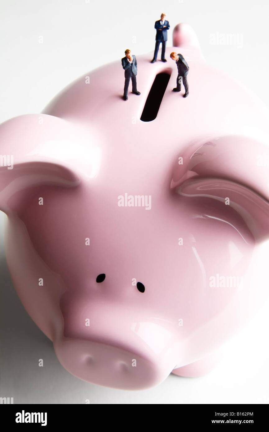 Businessman figurines standing on a piggy bank Stock Photo - Alamy