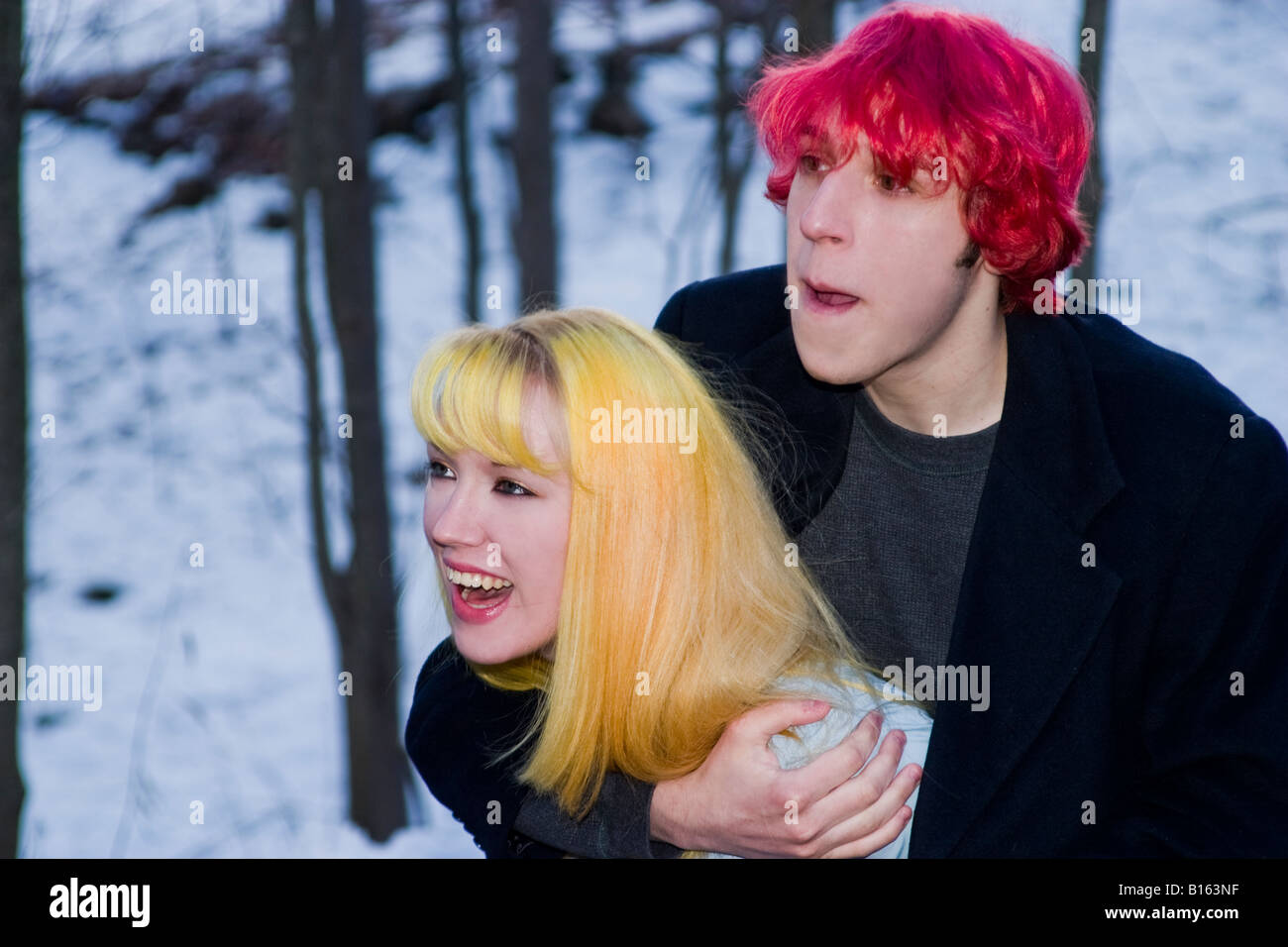 Teen boy with dyed red hair joking around outside with his blond girlfriend Model Released Stock Photo