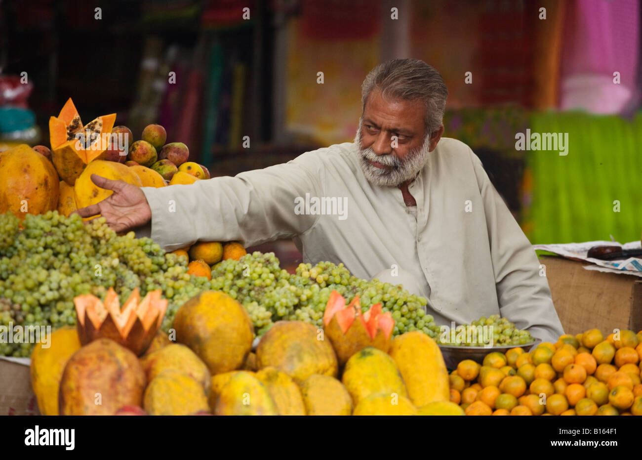 A RAJASTHANI MAN sells PAPAYAS and GRAPES in JODHPUR also known as the BLUE CITY RAJASTHAN INDIA Stock Photo