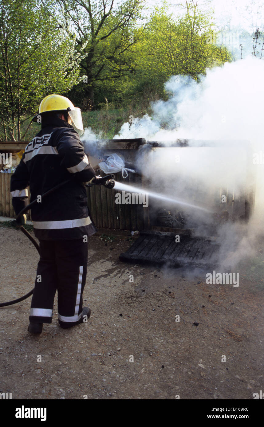 Firefighter Attending A Fire In A Litter Bin Stock Photo