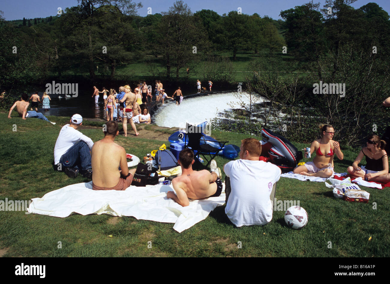 Young People Enjoying The Sun By The River At Chatsworth House Stock Photo