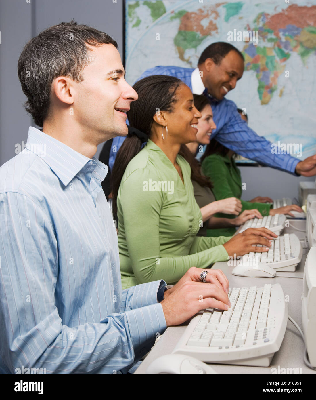 Multi-ethnic businesspeople typing on computers Stock Photo - Alamy
