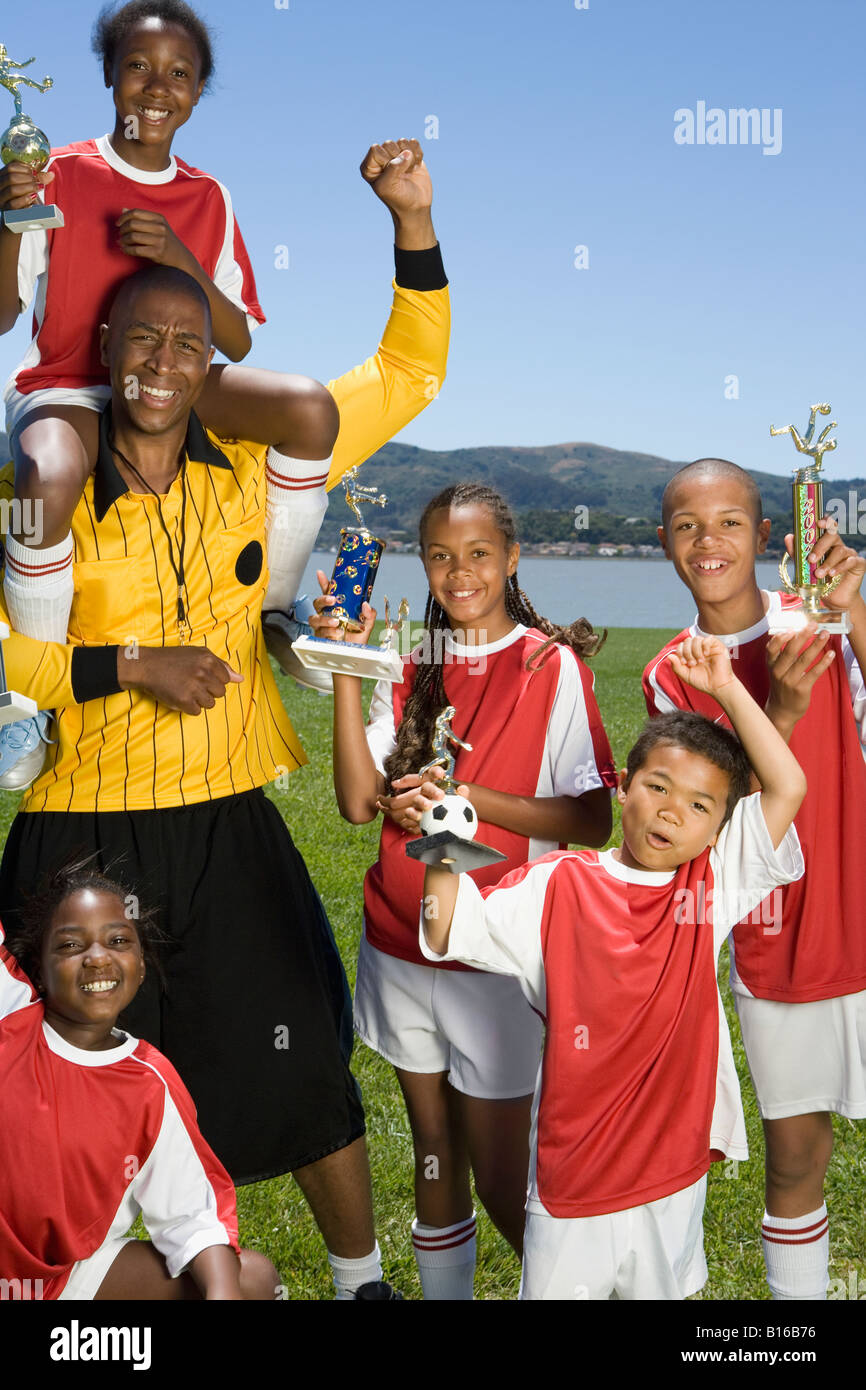 Multi-ethnic children holding soccer trophies Stock Photo