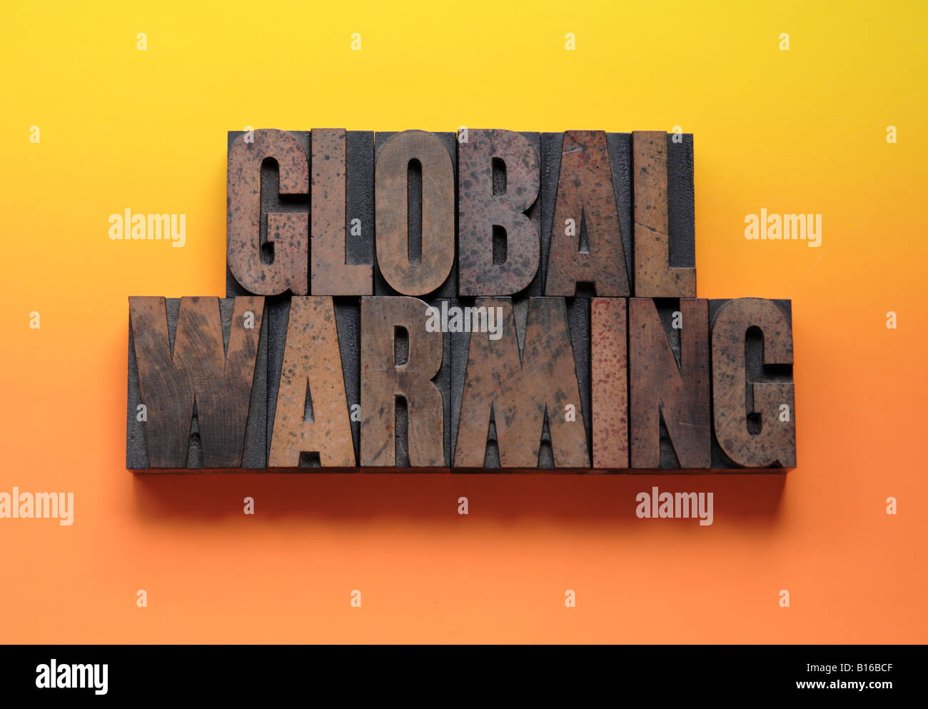 the phrase 'global warming' in letterpress wood type on a yellow and orange  background Stock Photo