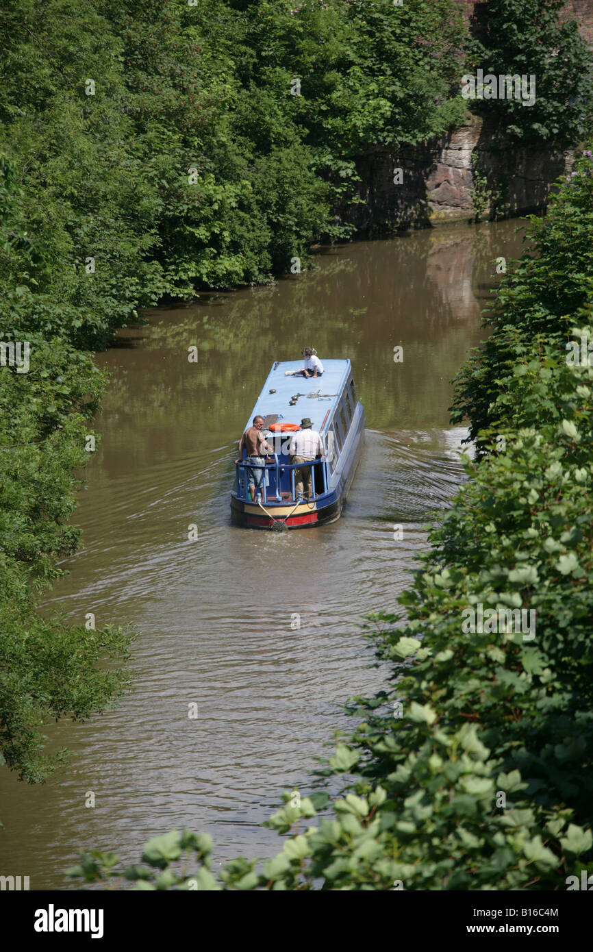 City of Chester, England. A canal boat transiting through Chester Canal on the Shropshire Union Canal at Chester city wall. Stock Photo